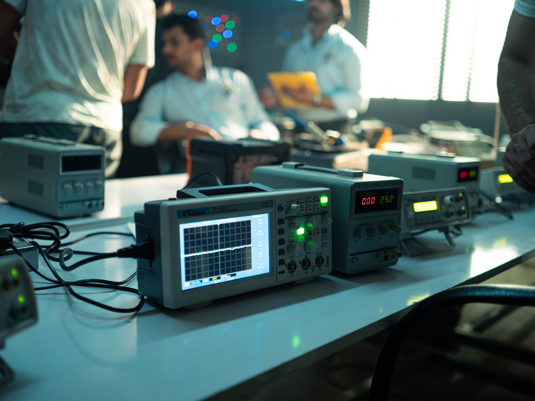 Engineers collaborating on technical testing in an electronics laboratory